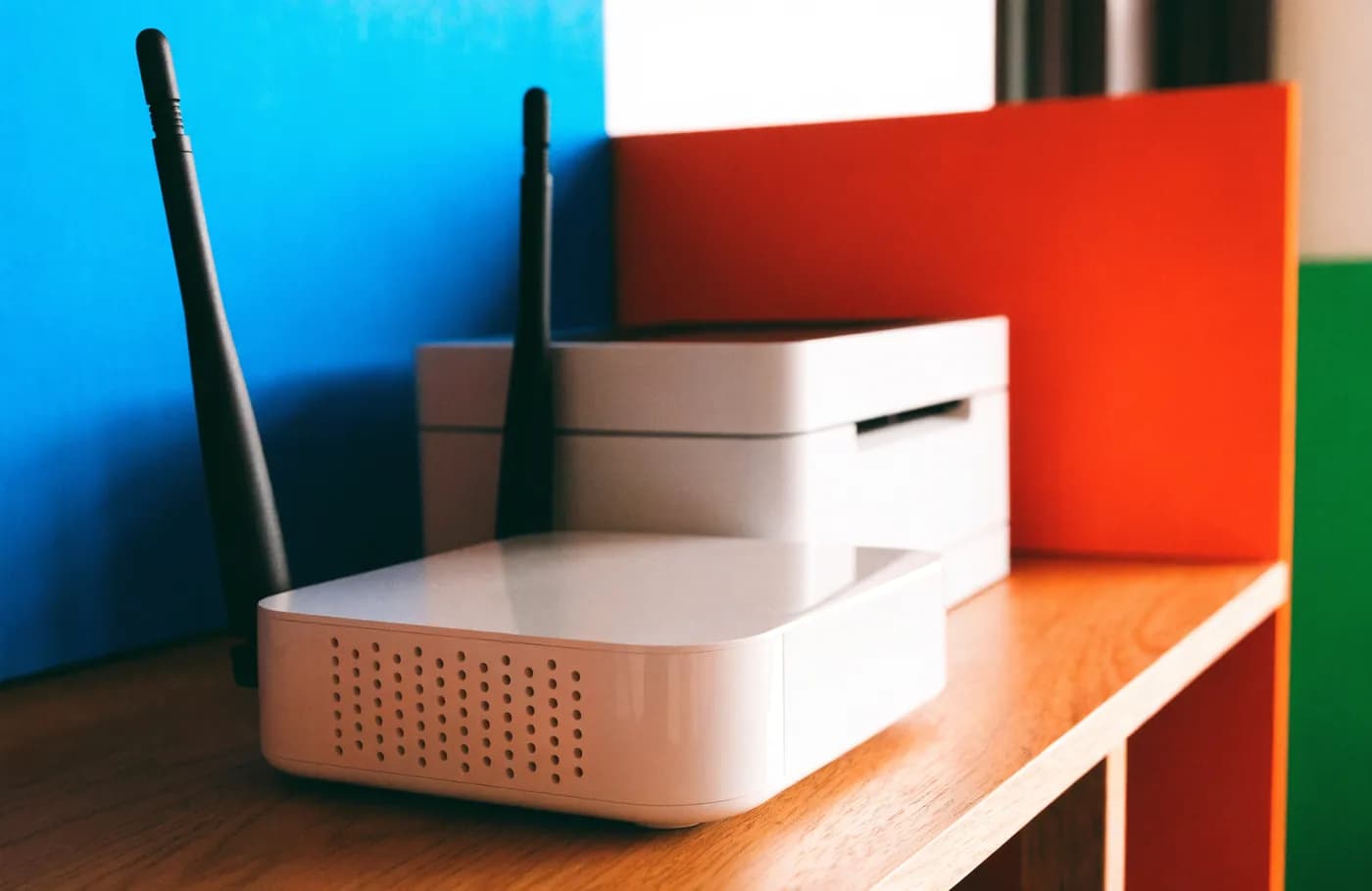 Un routeur wifi et une imprimante posés sur la même étagère